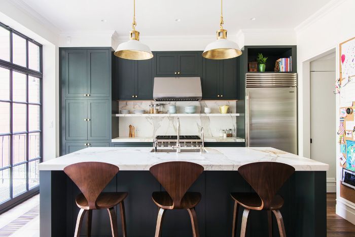 Kitchen with white counter, dark cabinets and stylish chairs