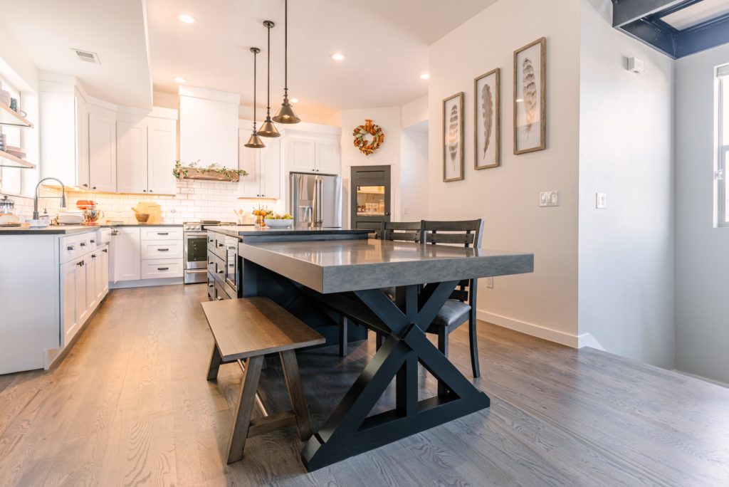 Remodeled kitchen with white cabinets and custom table