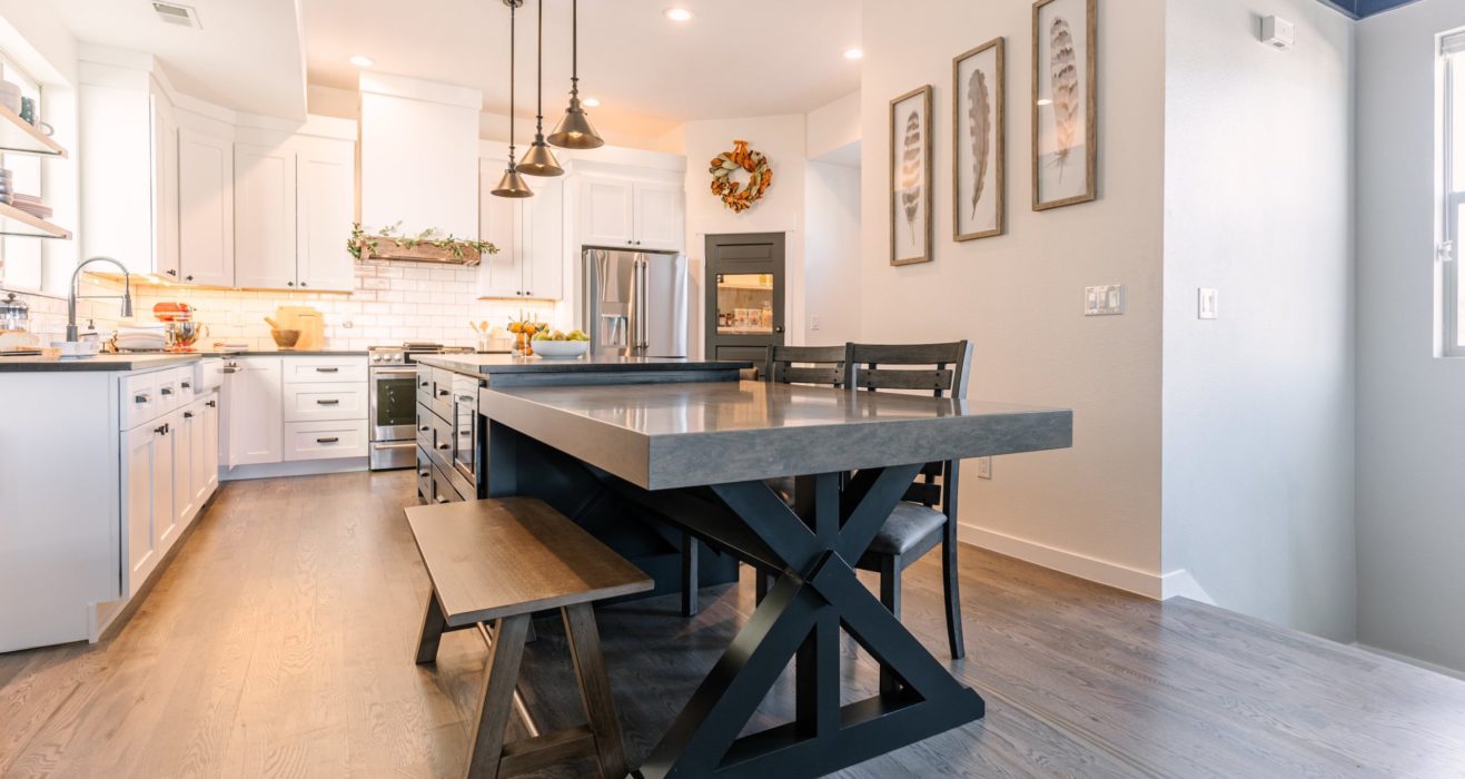 Remodeled kitchen with white cabinets and custom table